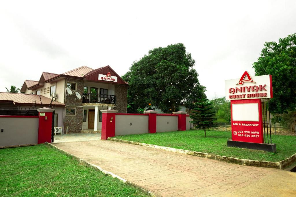 a sign in front of a house with a yard at Aniyak Guest House in Sekondi-Takoradi