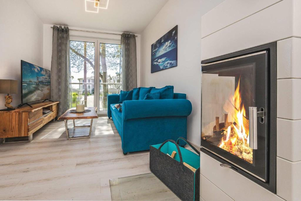 a living room with a blue couch and a fireplace at An der Haffküste Meerzeit in Zirchow