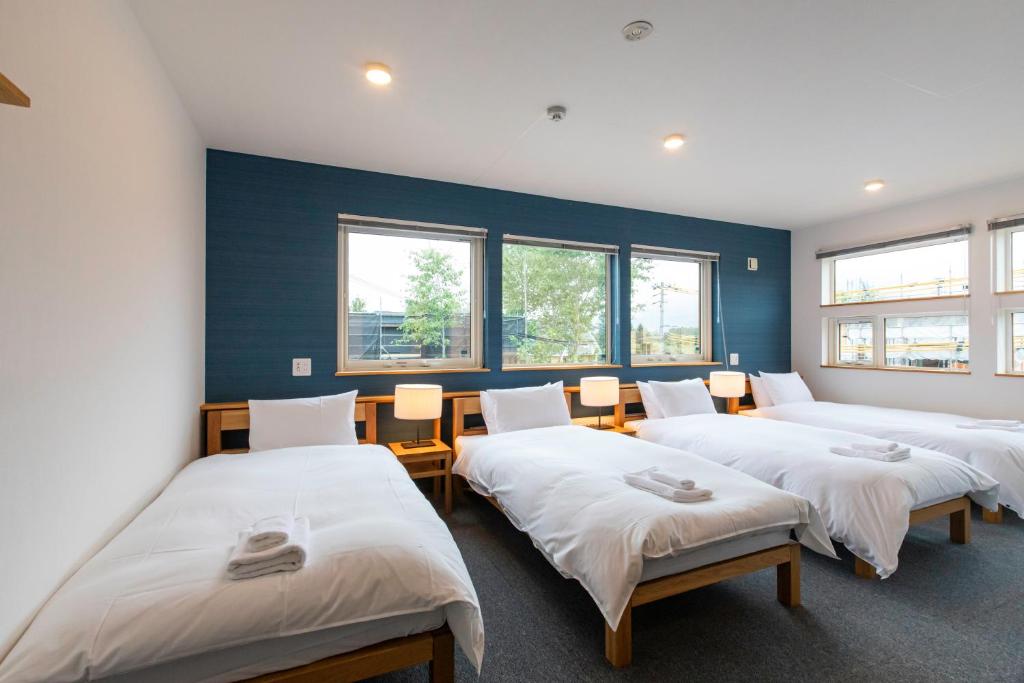 a row of beds in a room with windows at Hirafu Tomten in Kutchan
