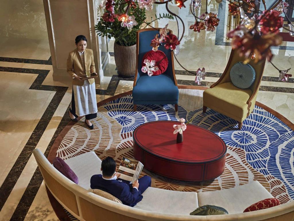 a man sitting in a chair in a living room at Grand Mercure Hanoi in Hanoi