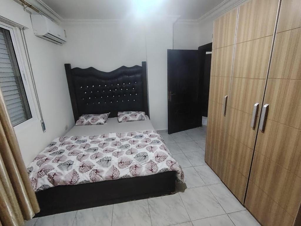 a bedroom with a bed and a wooden cabinet at شقة خلف السيفوي in Irbid