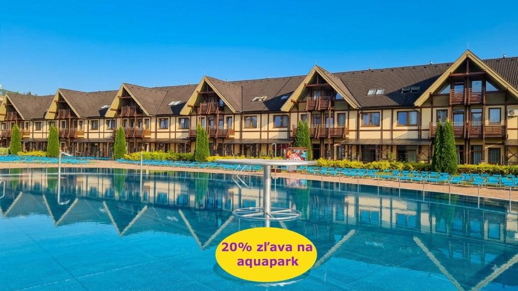 a resort with a swimming pool in front of it at Bešeňová Apartment in Bešeňová