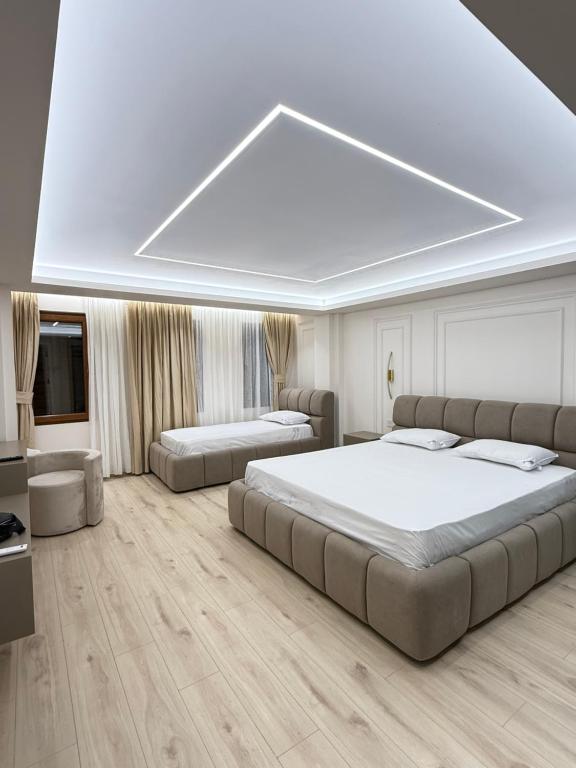 a large bedroom with two beds and a television at Old Town Inn in Pogradec