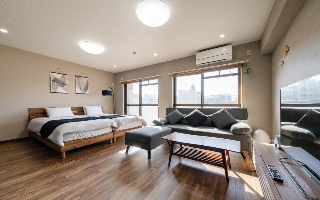 a bedroom with a bed and a couch in a room at fleuve tenmonkan in Yamashitachō