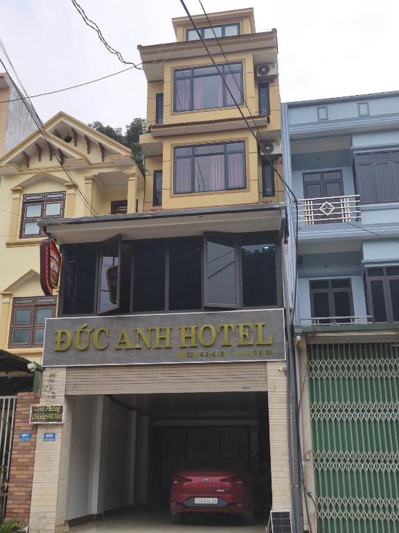 a building with a car parked under a garage at ĐỨC ANH HOTEL Bảo Lạc in Bảo Lạc