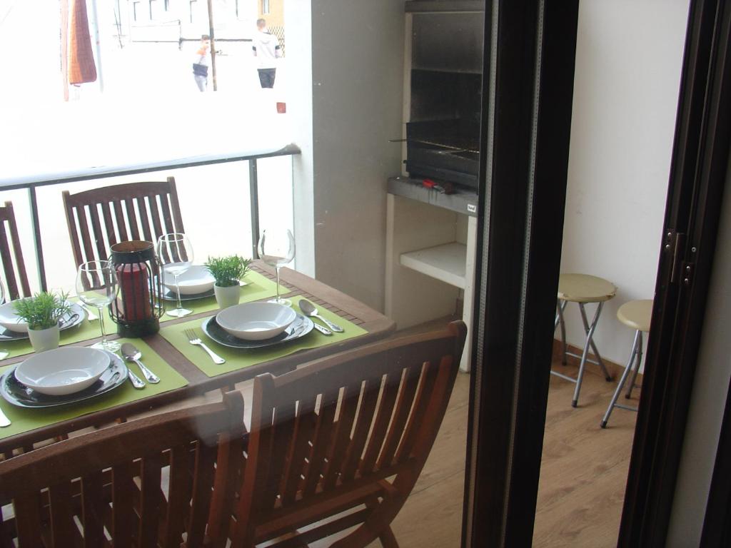 a dining room table with plates and utensils on it at Apartamento Sol e Mar 1 in Monte Gordo