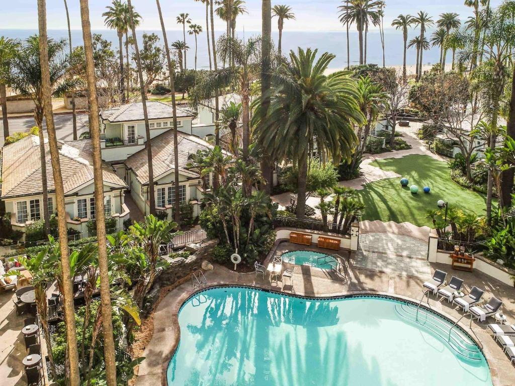 an aerial view of a resort with a pool and palm trees at Fairmont Miramar Hotel & Bungalows in Los Angeles
