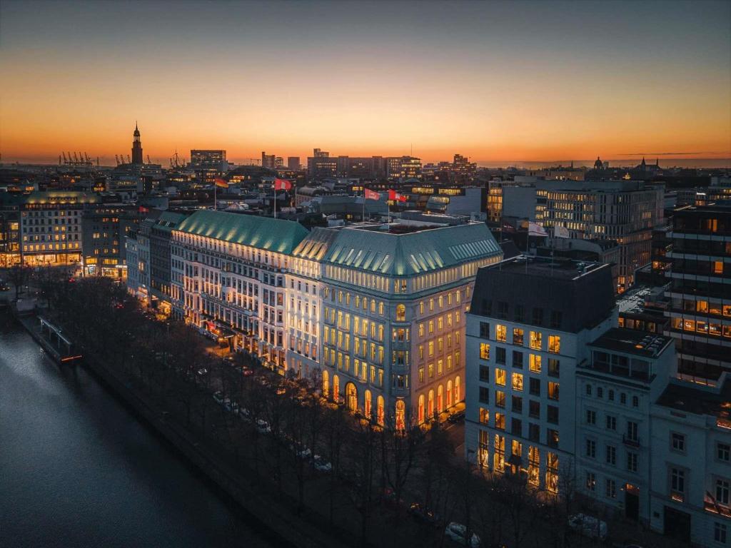 a lit up building in a city at sunset at Fairmont Hotel Vier Jahreszeiten in Hamburg