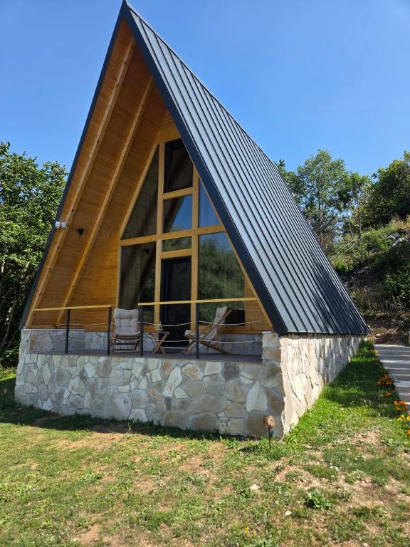 a cabin with a large window and a pitched roof at durmitor's golden peace in Šavnik