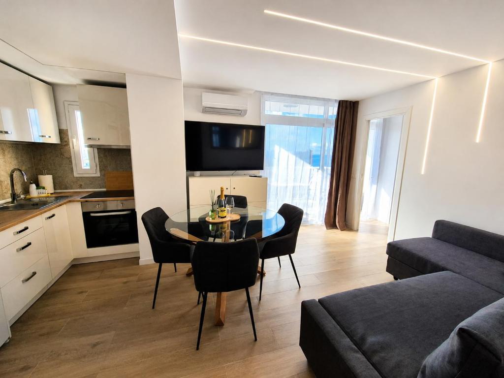 a kitchen and a living room with a table and chairs at Vibre Canaris - Las Americas in Playa de las Americas