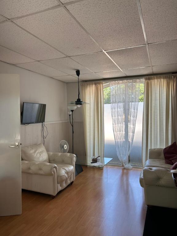 a living room with two white couches and a television at Vredig Toeven in Klaaswaal