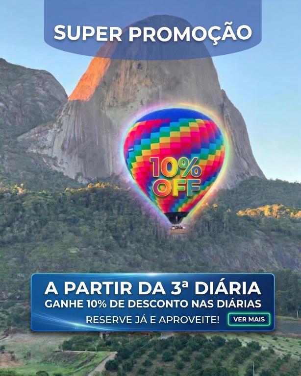a colorful hot air balloon in front of a mountain at Vista Azul Hotel Frente Pedra Azul in Pedra Azul