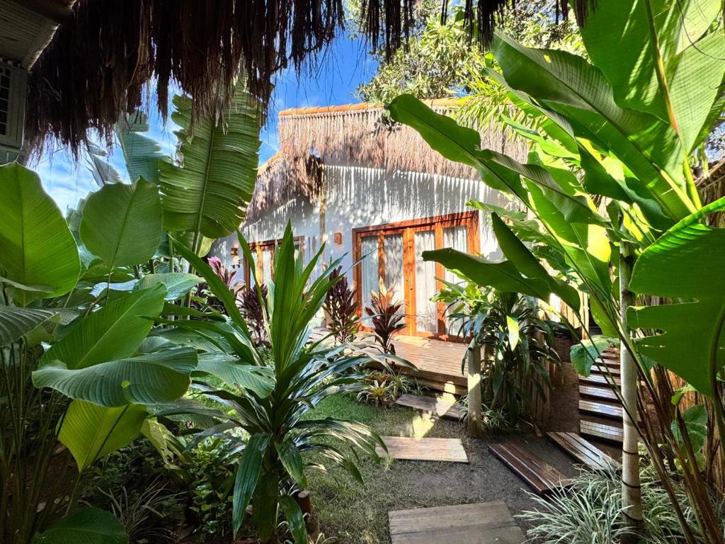 a house in the middle of a garden with plants at Casa Preguiça Corumbau in Corumbau