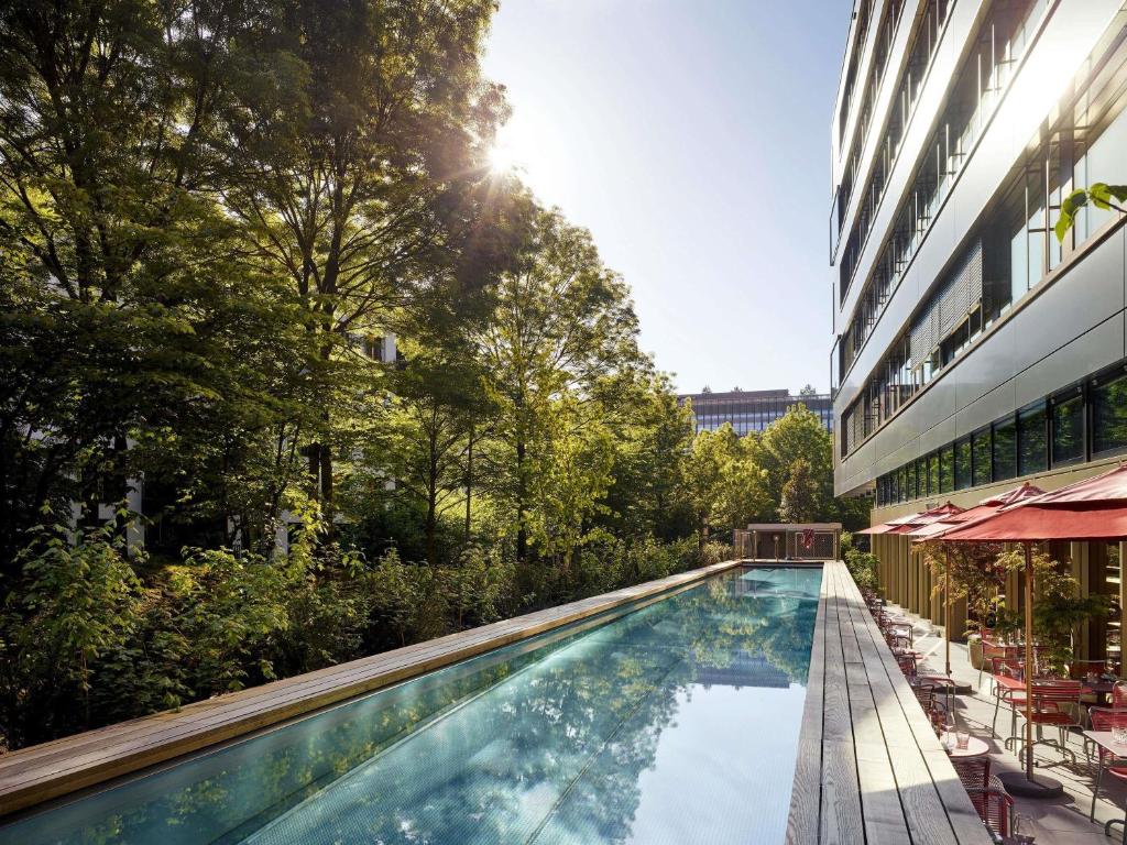 a swimming pool in front of a building at 25hours Hotel Zürich West in Zurich