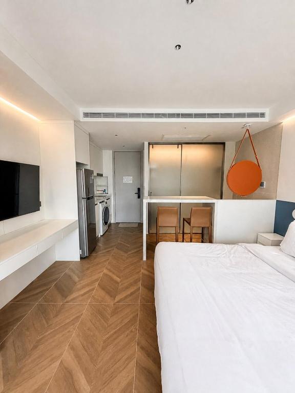a bedroom with a large white bed and a kitchen at Studio Apartment by Sunshine Beach in Layan Beach