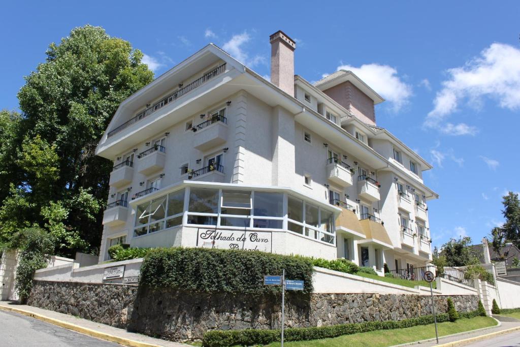 un grande edificio bianco sul lato di una strada di Pousada Telhado de Ouro a Campos do Jordão