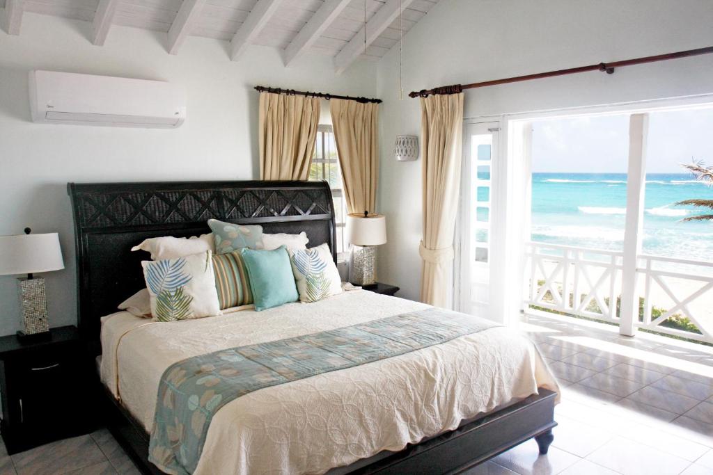 um quarto com uma cama e vista para o oceano em ZenBreak Silver Sands Villa 1 em Christ Church