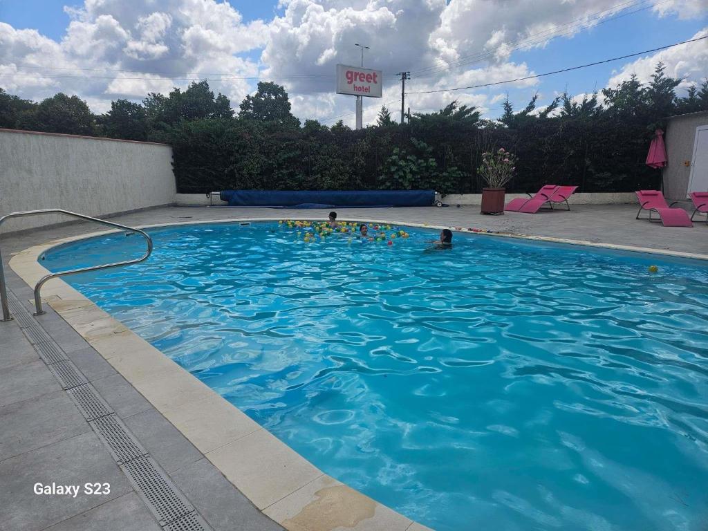 a large blue swimming pool with people in it at Greet Hôtel Castres Saix in Saix