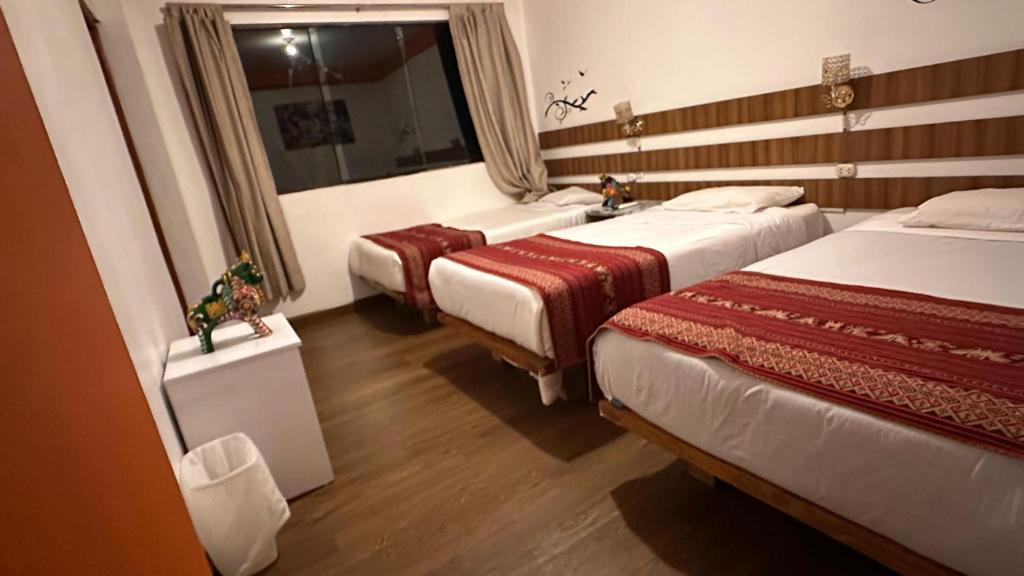 a hotel room with two beds and a mirror at All sur Cusco in Machu Picchu