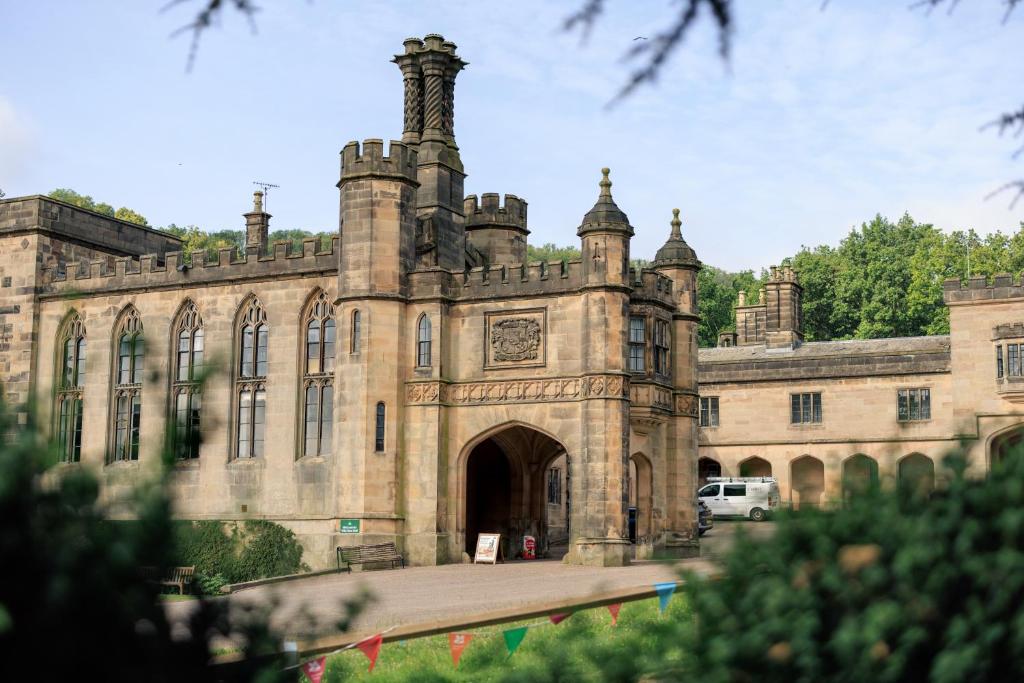 an old building with a car parked in front of it at YHA Ilam Hall in Ashbourne