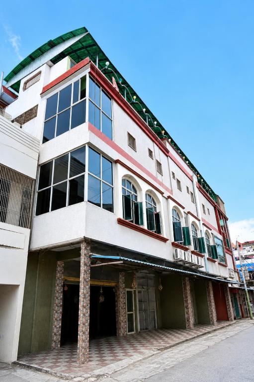 a large white building with windows on a street at Hotel Amaravathi Residency in Guntūr