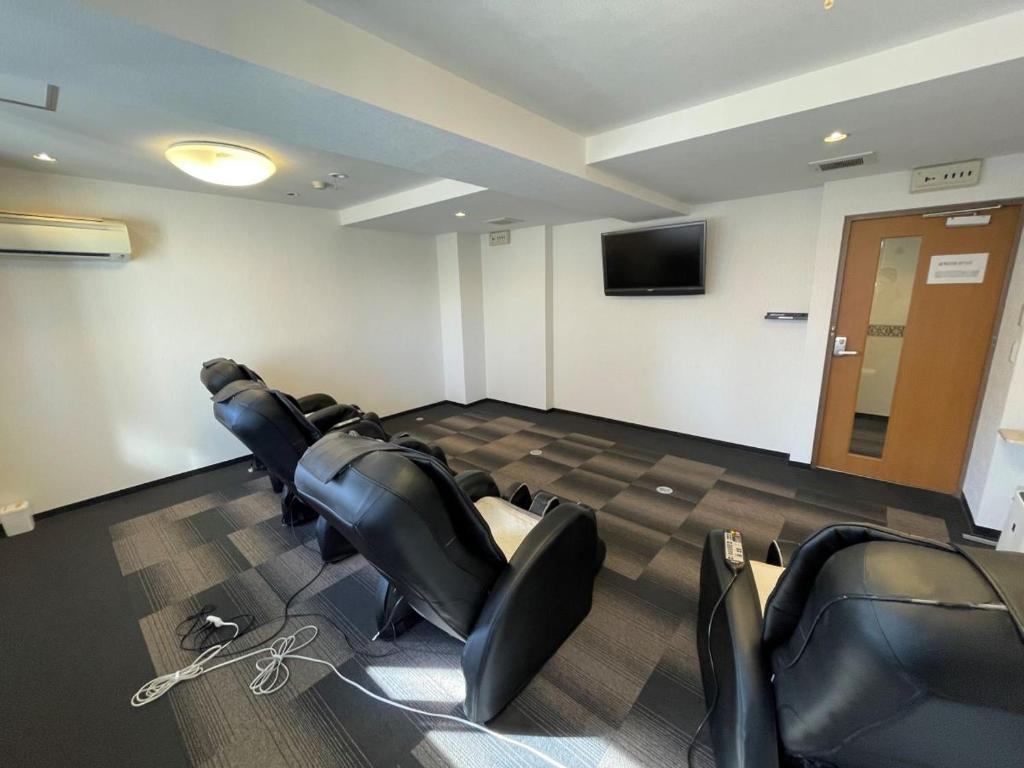 a conference room with chairs and a flat screen tv at Hotel Housen Soka in Soka