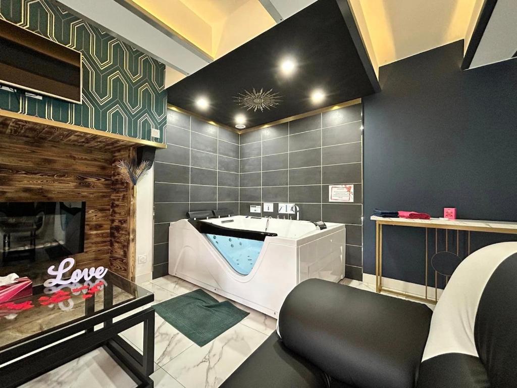 a bathroom with a tub and a fireplace at Le Petit Quiou in Le Quiou