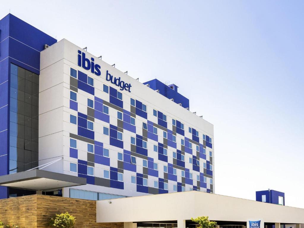 a blue and white building with a dogles hotel at Ibis Budget Farroupilha in Farroupilha