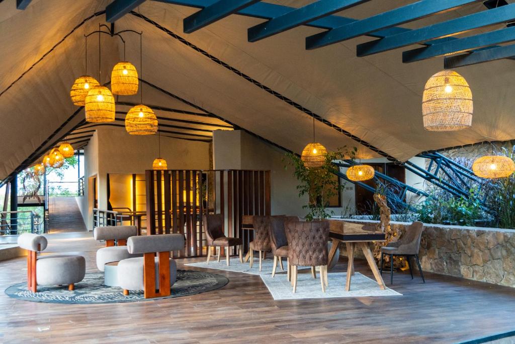 a lobby with a table and chairs and lights at Surana Mara Camp in Mara Simba