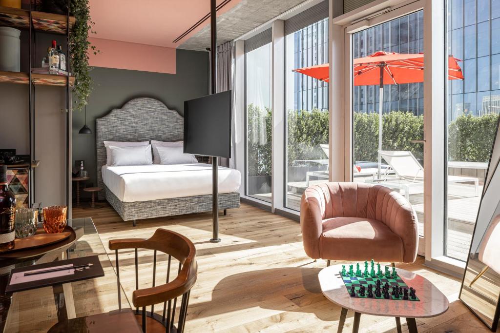 a hotel room with a bed and a table at Play Midtown Hotel Tel Aviv in Tel Aviv