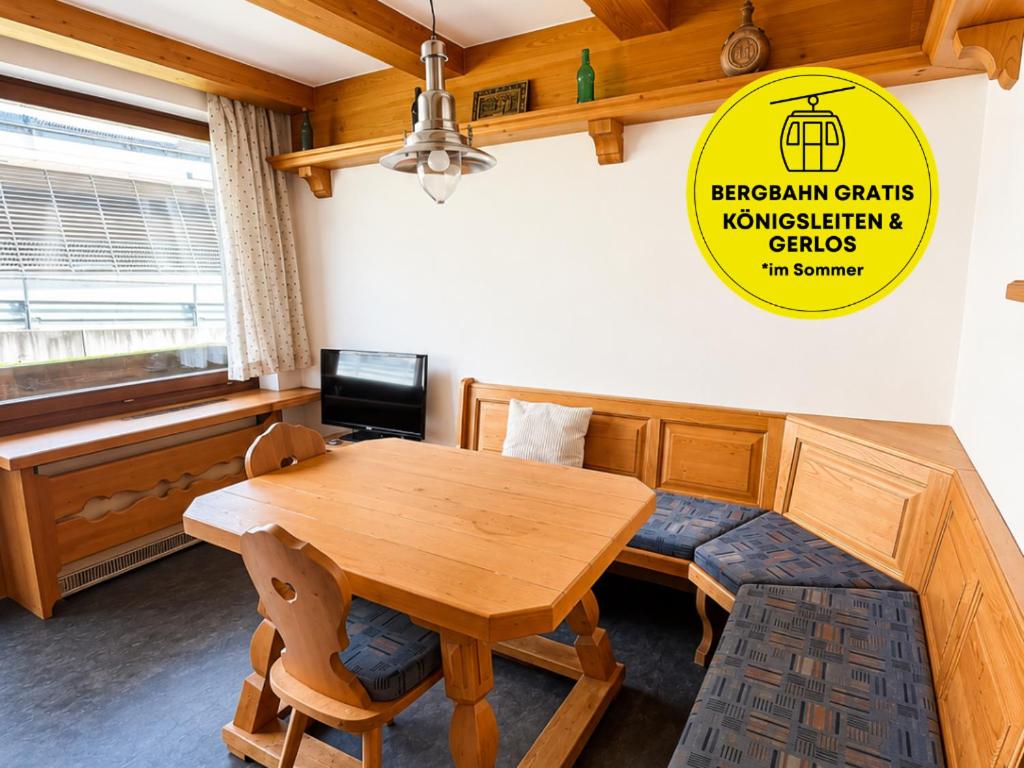 a dining room with a wooden table and a bench at Haus am Anger Top 42 in Königsleiten