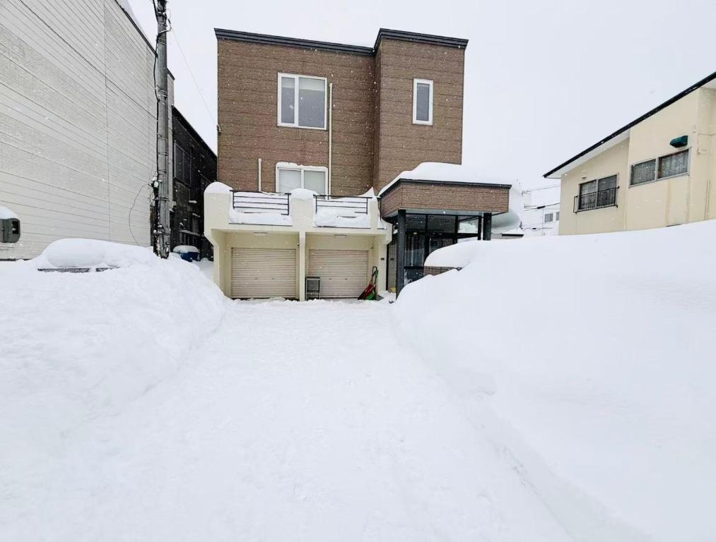 a pile of snow in front of a house at Sapporo Vacation Home B&B in Sapporo