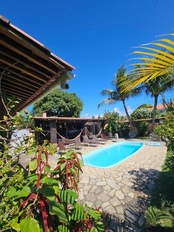 a resort with a swimming pool and palm trees at Aloha Beach Guest House in Maragogi