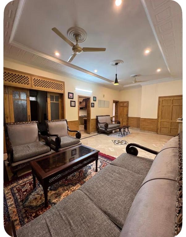 a living room with couches and a coffee table at 4Bdr Spacious Hill View Central E 11 TV Netflix in Islamabad