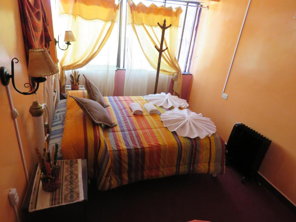 a bedroom with a bed with a window and a table at Hostal "Oro Blanco" in Uyuni