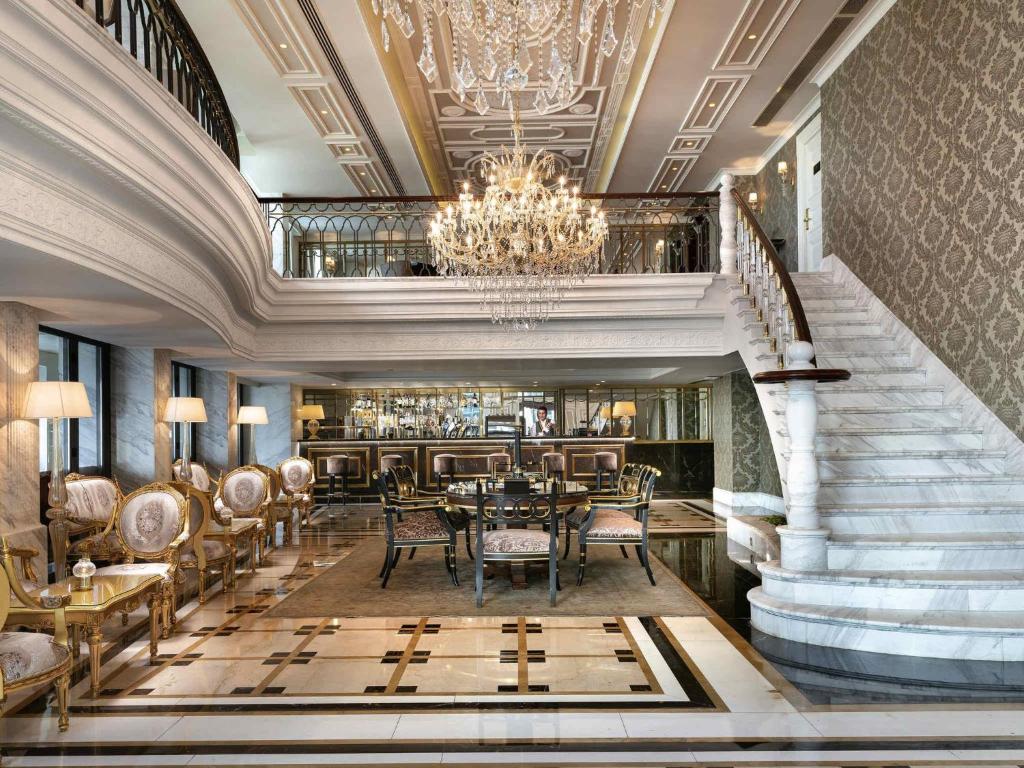 a dining room with a chandelier and a staircase at Rixos Pera Istanbul - Nickelodeon Play Access in Istanbul
