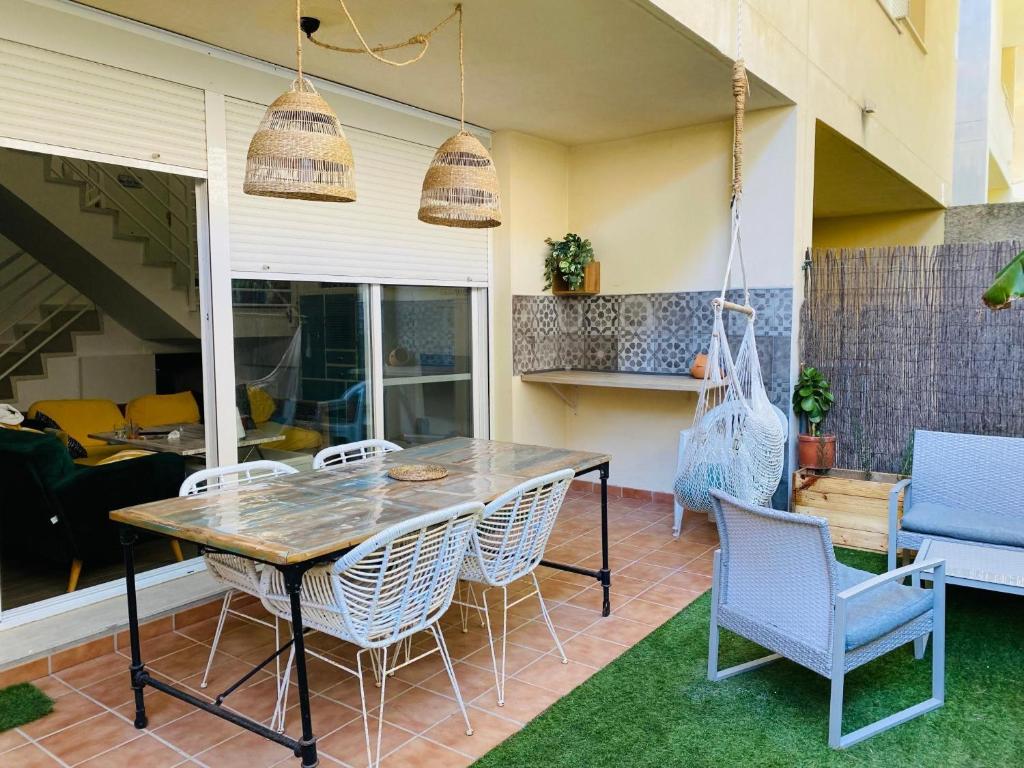 a patio with a wooden table and chairs at Marta Beach House - Caños De Meca in Los Caños de Meca