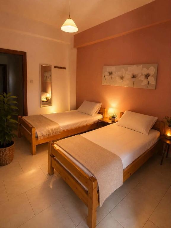 a bedroom with two beds and a potted plant at Yfantis Sakis Apartment's in Erateini