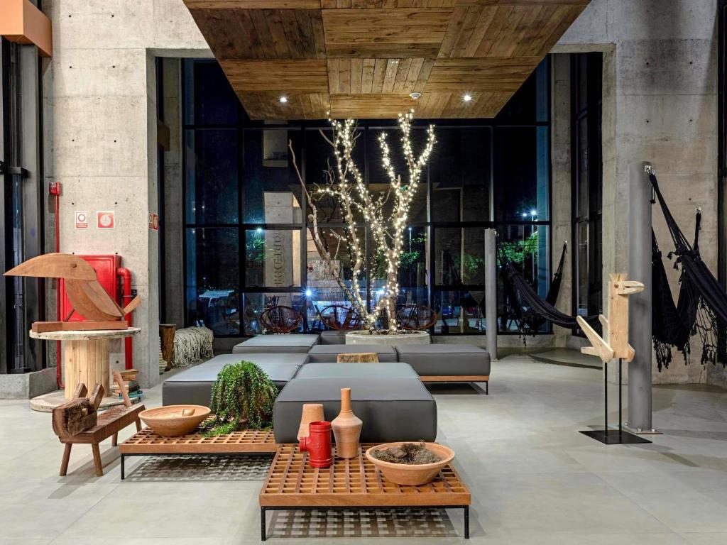 a lobby with a couch and tables in a building at ibis Styles Maceió Pajuçara in Maceió