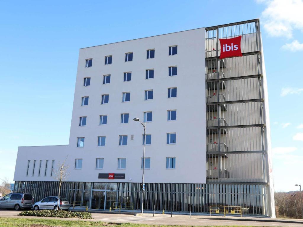 a white building with a ups sign on it at Ibis Bourgoin Jallieu Medipole in Bourgoin