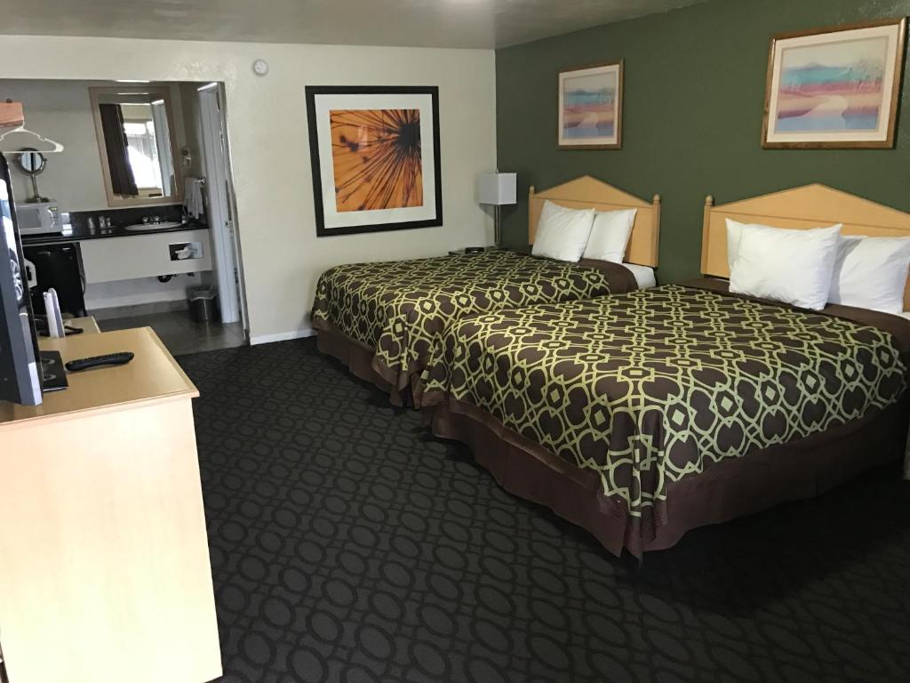 a hotel room with a large bed and a bathroom at Downtown Inn in Eugene