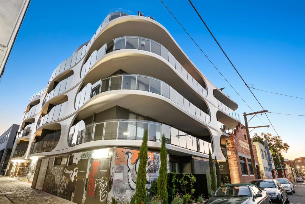 a white building on the side of a street at District Apartments Fitzroy in Melbourne