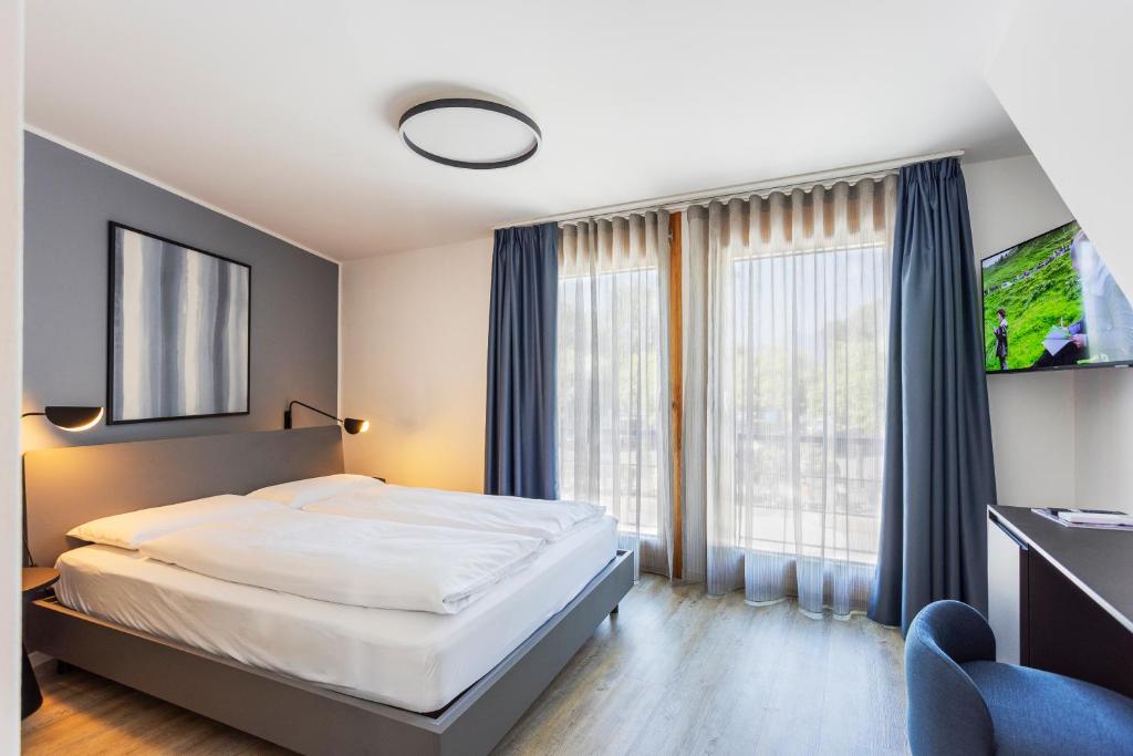 a bedroom with a bed and a large window at Osteria Ascona in Ascona