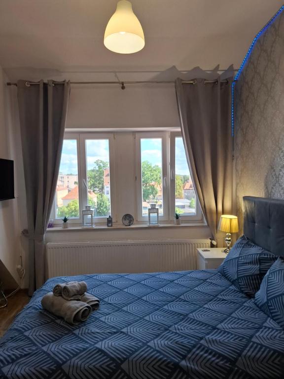 a bedroom with a bed with a towel on it at Kameralny Apartament w Centrum in Szczytno