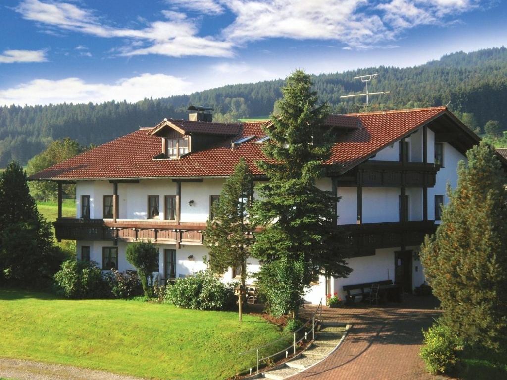 ein großes weißes Haus mit rotem Dach in der Unterkunft Gasthof-Pension-Kraus in Achslach