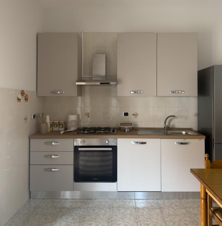 a kitchen with white cabinets and a stove top oven at Unit 120 in SantʼAgata di Militello