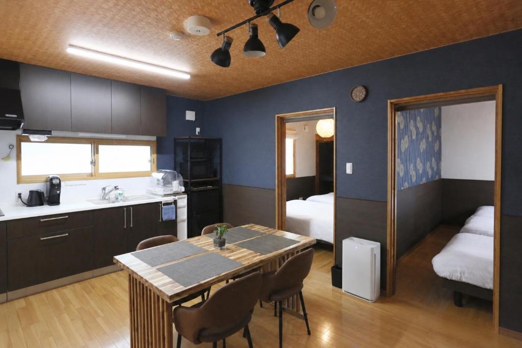 a kitchen with a table and a room with a bed at Chillax Hida Takayama in Takayama