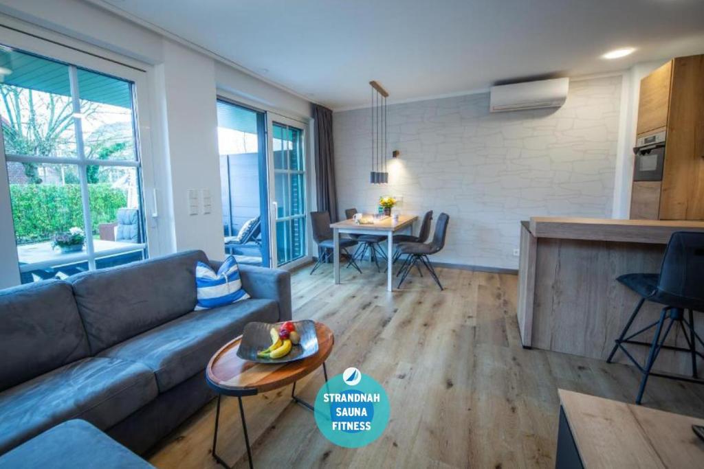 a living room with a couch and a table at Winkelschiffchen III mit Sauna in Juist