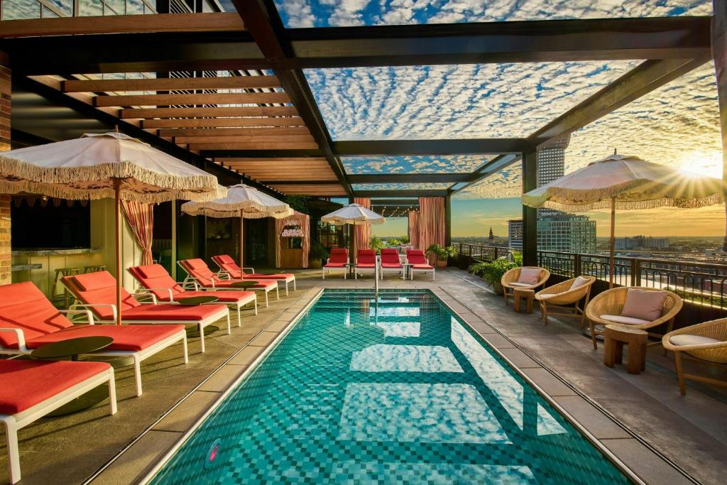 a pool with chairs and umbrellas on a building at Virgin Hotels New Orleans in New Orleans