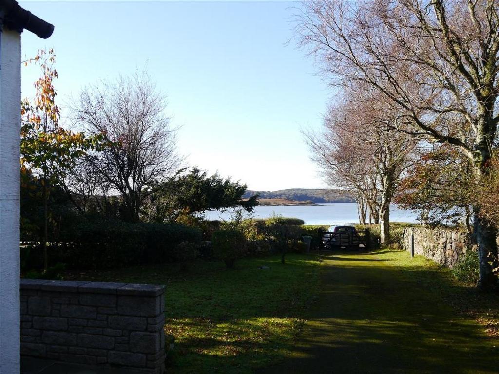 a yard with a view of a body of water at Calluna Cottage in Rockcliffe